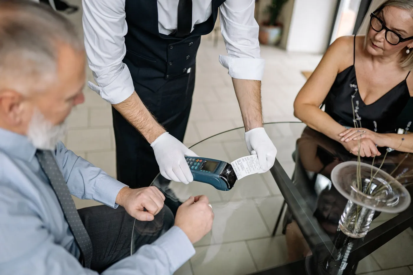 A card payment terminal held out to a customer at a restaurant table