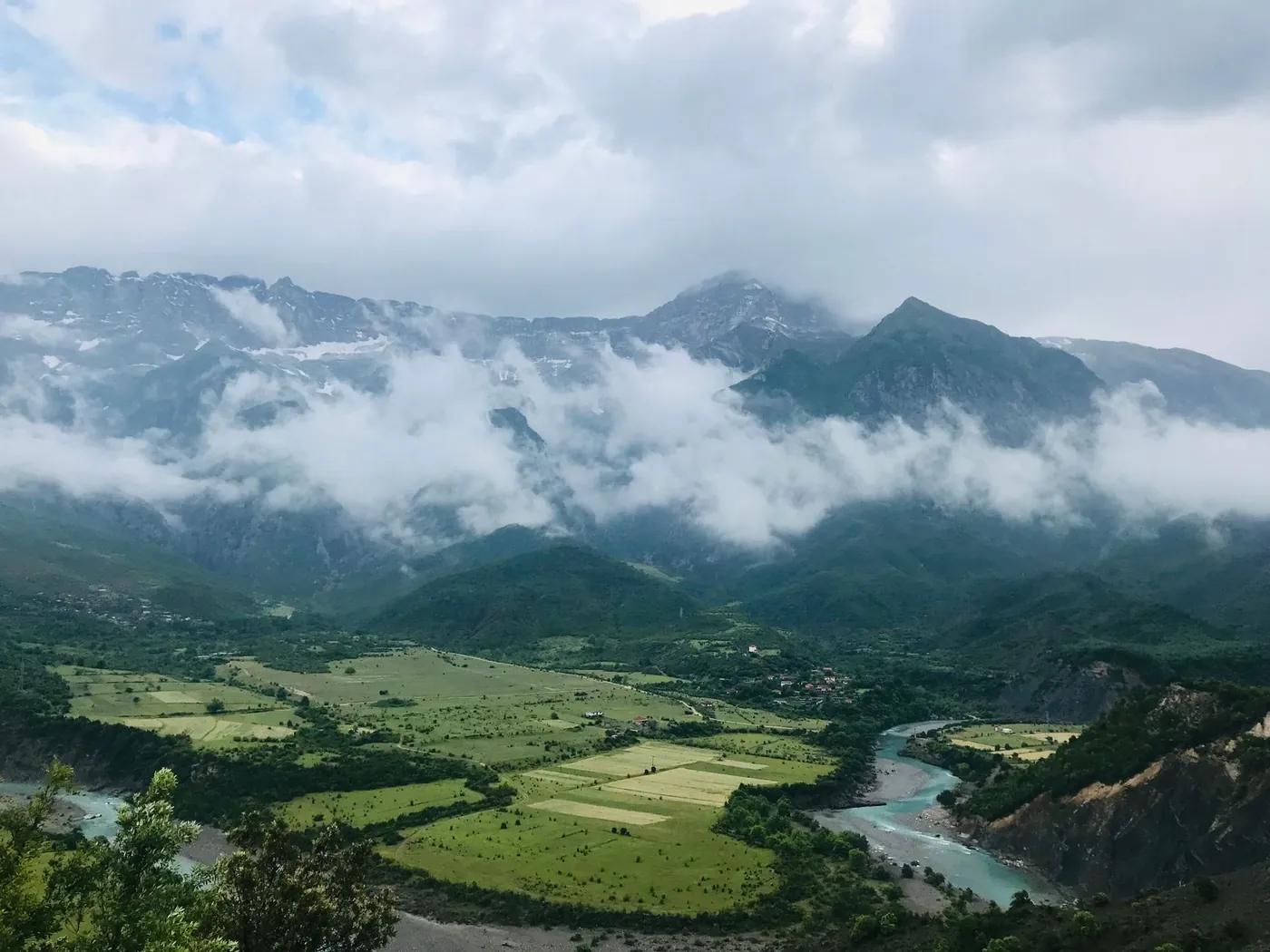 Small town of Permet beside a river with mountains behind
