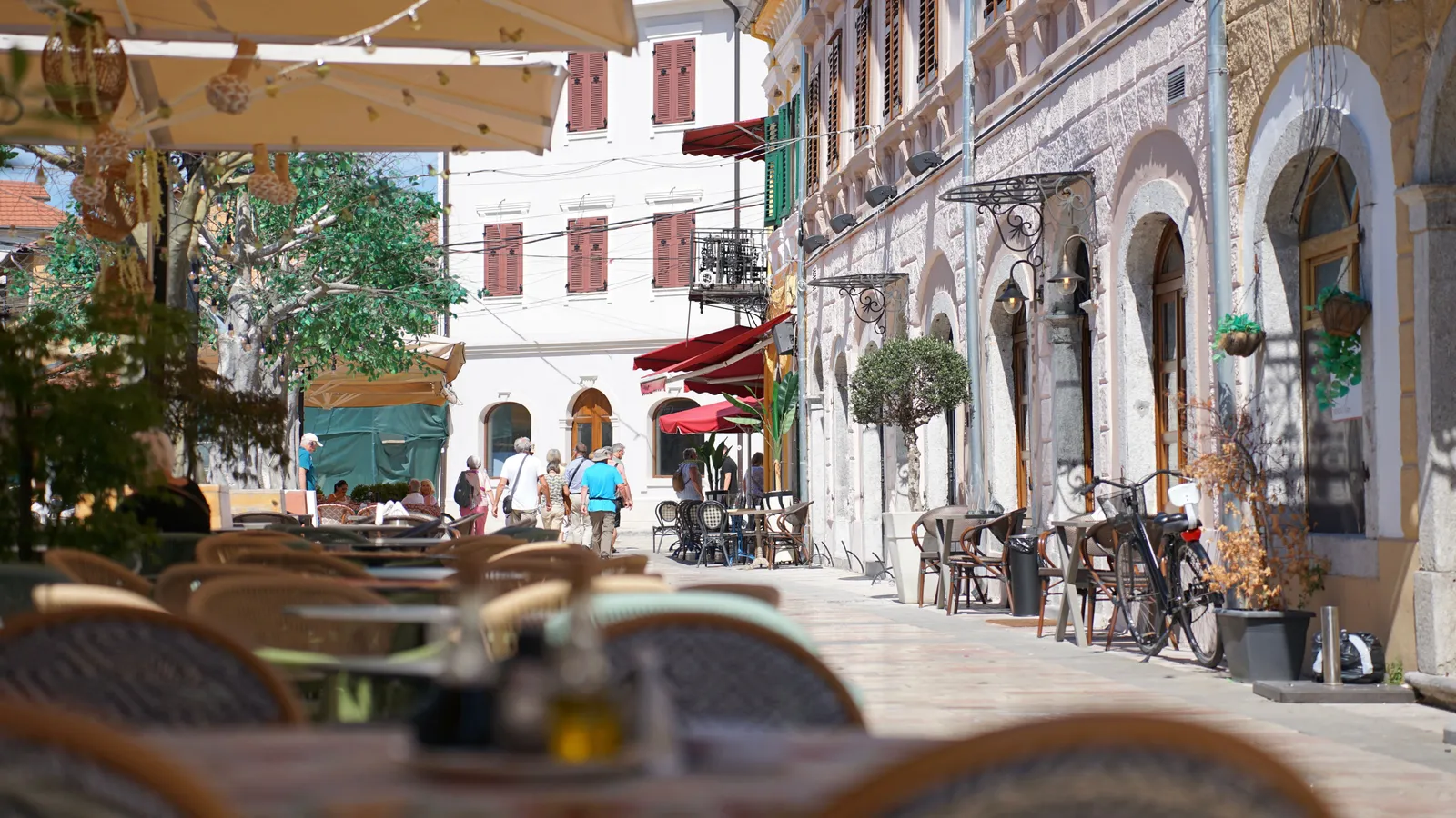 Pedestrian street in Shkoder with cafes and people walking in the evening