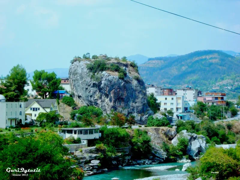 A great rock above a green town