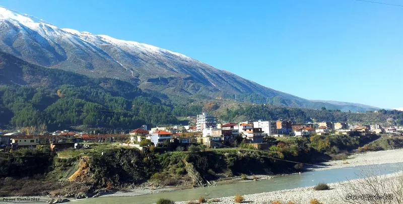 A wide river valley with a snow capped peak behind