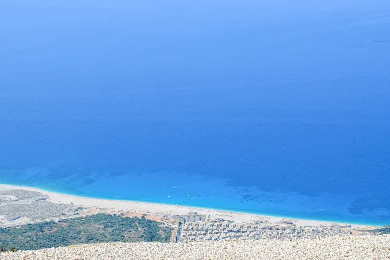 Turquoise water against a white pebble shore