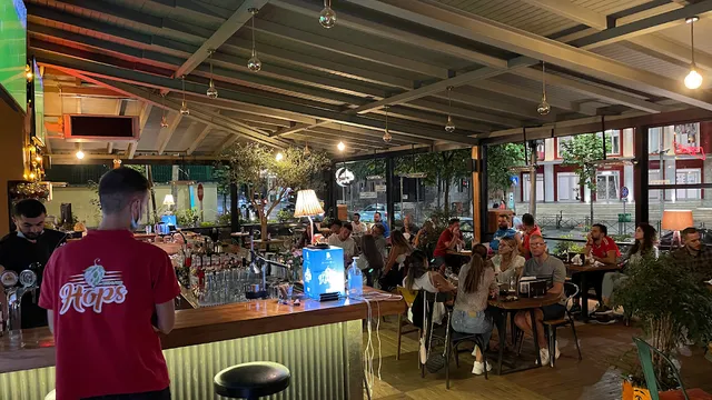 A covered evening bar with beer taps, diners at tables and warm lighting