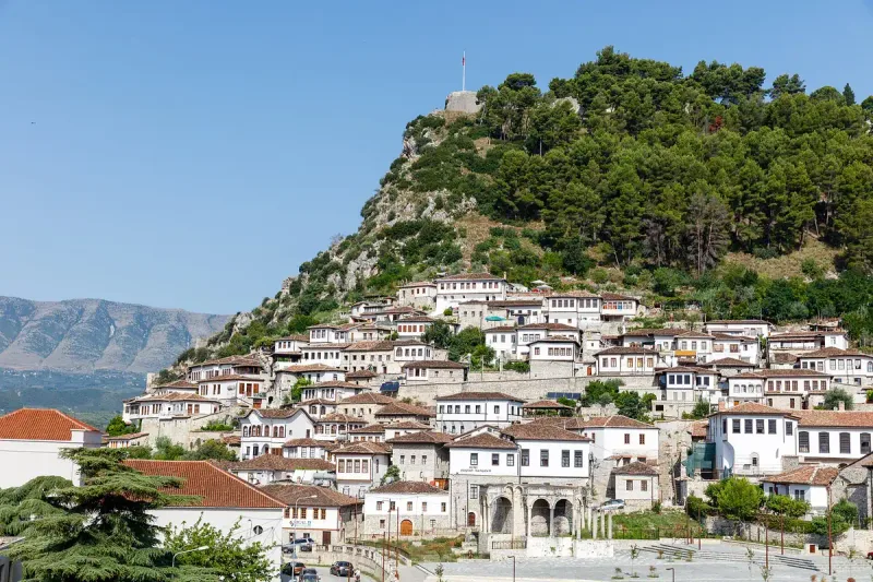 White stone houses below a castle hill