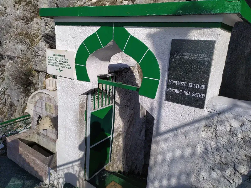 A green and white gateway to a shrine on the mountain