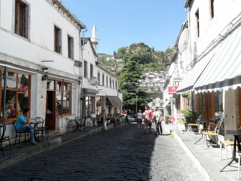A stone paved street with shops and cafes