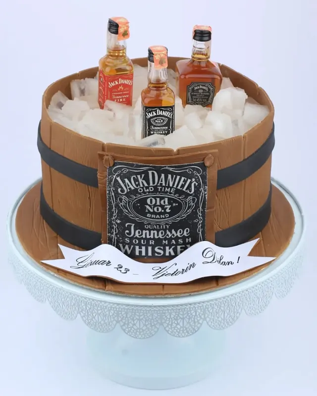 A cake designed as a wooden barrel with small whiskey bottles set in ice cubes