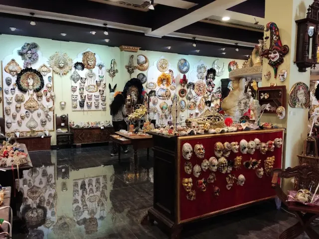 A showroom with hundreds of decorated masks on the walls and on a red cabinet