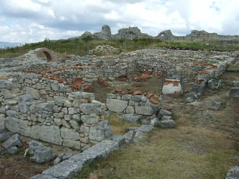Stone wall remains and clay pipes of an ancient city on an open hilltop